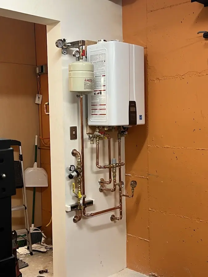 Plumbing technician inspecting water heater connections in Wheaton